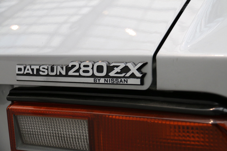 「280ZX」のリアエンブレム。長年米国で親しまれていたDATSUNからNISSANへとブランド名を移行させるのに苦労していた、当時の様子がしのばれる。