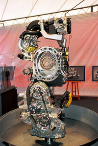 サイド排気を採用した「RENESIS」ユニットのカットモデル。2倍の排気ポート面積を確保する一方、吸気ポート面積を約30％拡大。かつクローズドタイミングを遅らせることにより、混合機の流入量を増大、パワーアップにつなげた。210ps版は2段階、250psバージョンは3段階に吸気タイミングを変化させる「シーケンシャル・ダイナミック・エアインテーク・システム」を採る。「いわば、ロータリーエンジンのVTEC」と、担当エンジニアの方が説明された。（写真＝荒川正幸）
    
    