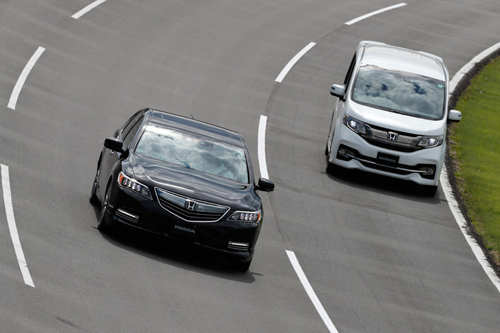 高速周回路にて、自動で車線を変更して、走行車線の「ステップワゴン」を追い抜く「レジェンド」。