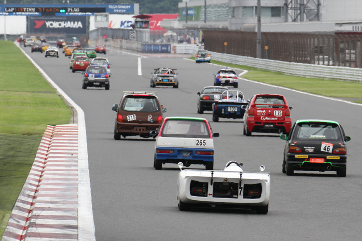 レース中盤、最終コーナーを立ち上がってメインストレートを行く参加車両。