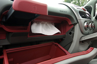 実はiの収納スペースはそれほど多くない。助手席のグローブボックスやドリンクホルダーなどがあるが、ATシフター前方、インパネ真下にある底の浅い収納はちょっと意味不明。うかつに物を置いてペダルとフロアの間に転がり落ちたりしたら……。フロアではなくコラムシフトにして前席間のスペースを稼いだほうがよかったのでは？クリックすると、“隠れティッシュボックス”が登場。これは便利。