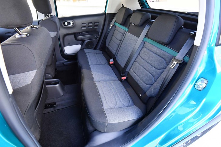 一方の後席は、やや小ぶりで座面が短い印象。前席同様、だ円のパターンやエメラルドグリーンの差し色が個性的。