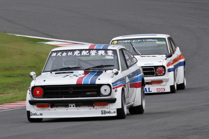 Fレース予選で引っ張り合う1972年「光配管興業ビルズ・サニー」と1972年「浅間レーシングGTサニー」。型式名KB110こと「ダットサン・サニー1200クーペ」である。決勝では前者が総合6位で、後者が4位。