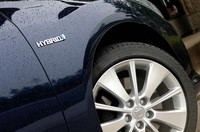 専用ホイールの傍らには、やはり専用の「ハイブリッド」エンブレム。ボディカラーは、白黒青銀系の全6色が用意される。（試乗車はダークブルーマイカ）