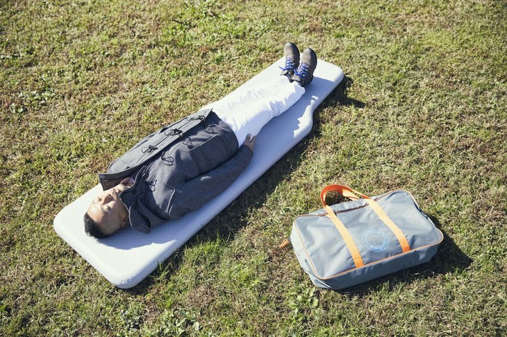 大きくて快適な「N-VAN用クイックエアマット シングルベッドタイプ」はホワイトハウスが販売するアイテム。長さは214cmで、身長172cmの筆者（写真）にとっては余裕たっぷり。写真右のバッグに収納する。