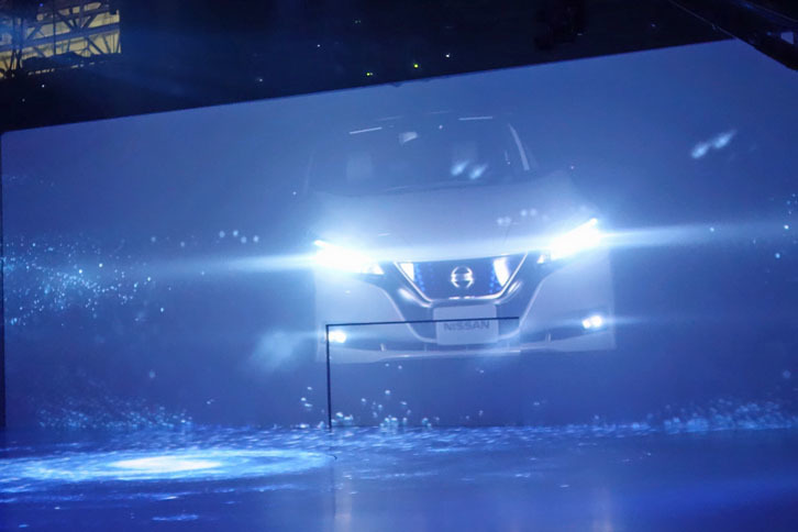 プロジェクションマッピングの中に姿を現した新型「リーフ」。先代よりも精悍（せいかん）なフロントマスクを備えている。