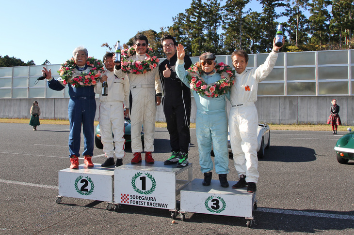 「セブリング40mトロフィー」終了後、コース上での暫定表彰。2位表彰台左側のヒゲ姿には見覚えが……なんと1985、86年の全日本ツーリングカー選手権連覇をはじめ1980～90年代に国内外のレースで活躍した長坂尚樹氏だった。そして3位表彰台の右側は、1980年から始まったFJ1600の初代チャンピオンである坂本典正氏。並の草レースじゃないのである。