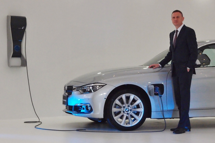 給電口は、左のフロントフェンダー部分に設けられている。写真で傍らに立つのは、BMWジャパンのペーター・クロンシュナーブル社長。「プラグインハイブリッド車は今後、BMWが考えるサステイナブル・モビリティーの柱になる」などとコメントした。