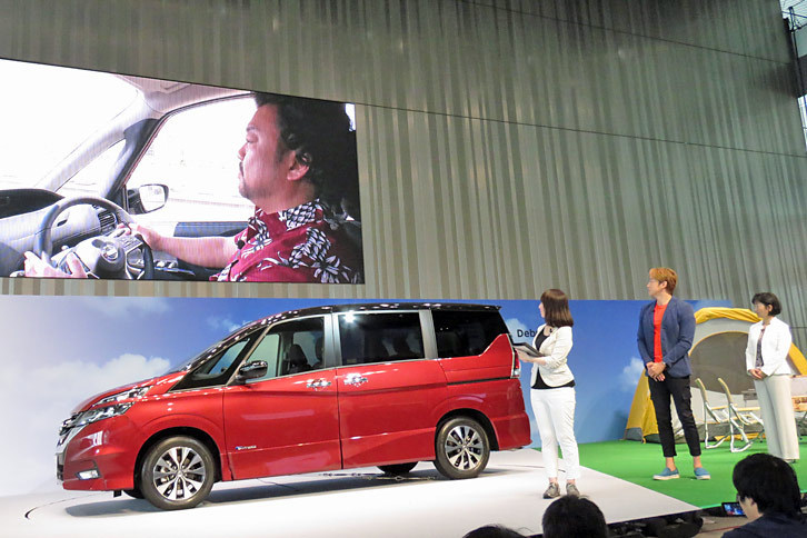 会場のスクリーンに、高速道路を走る「セレナ」の車内が映る。運転しているのは、タレントで振付師のパパイヤ鈴木さん。