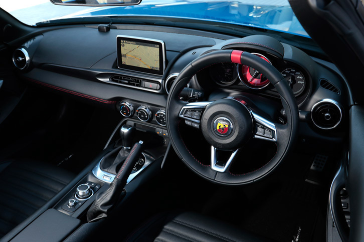 赤く塗られたタコメーターがスポーティーさを主張するインストゥルメントパネル。ステアリングホイールの形状も「マツダ・ロードスター」とやや異なっている。