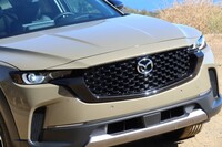 「CX-50」のグリルは「CX-5」のそれに比べて、大きくワイド。フロントまわりは一段と精悍（せいかん）なデザインに。