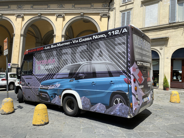 （写真K）。スズキの販売代理店によるラッピング広告で彩られた小型路線バス。