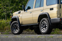 40年の歳月を感じさせる“増築”の一例。“70”は2007年にV型エンジン搭載のためにフロントが拡幅されており、リアよりフロントのほうが95mmもトレッドが広くなった。結果、フロントの足もとは「ブリスターフェンダーの上に台形のオーバーフェンダー」という、R34 GT-Rもハダシで逃げ出す強引な造形をしているのだ。（写真：向後一宏）