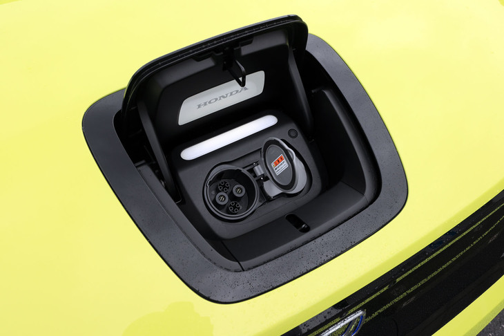 「ホンダe」の充電口は普通充電、急速充電ともにフロントに装備。「常日ごろ触れるところだから、質感の高いものにしたかった」という開発者のこだわりから、リッドは手触りのよいガラス製となっている。