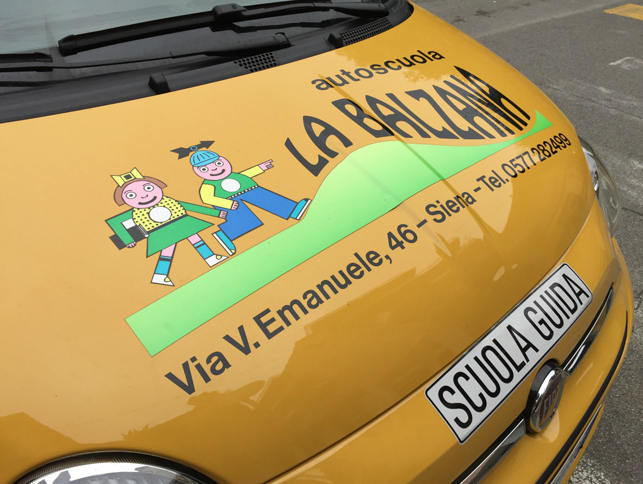 バルツァナ自動車教習所のロゴマーク。イタリアの教習車には、法定の「SCUOLA GUIDA」ステッカー（写真右下）が貼られている。