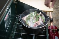 下ごしらえをしたマグロのカマを、ローズマリーとともにダッチオーブンの中へ。