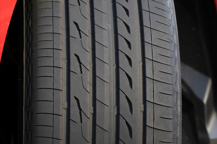 トレッド面に繰り返し彫られた“穴”に注目。これは「シングルブランチ型消音器」と呼ばれるもので、タイヤのミゾを通る空気の共鳴を抑制。ショルダー部のブロックを貫通する「突き通しサイプ」も、パターンノイズの低減に寄与する。