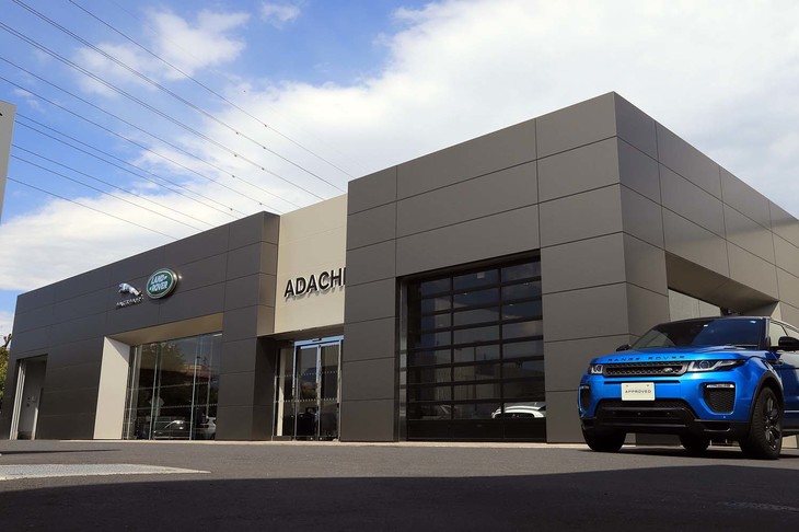 「ジャガー・ランドローバー・アプルーブド足立」は、首都高速川口線の鹿浜橋出口のすぐそば、環状七号線沿いという好立地に位置する。