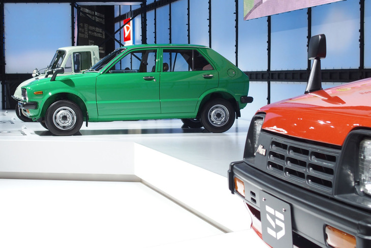 2023年10月に開催されたジャパンモビリティショーのダイハツブース。1980年の「ミラ」（写真手前）や1977年の「シャレード」（写真奥）など、ダイハツの歴史を象徴する車両と、その先にある未来を描いたコンセプトカーが展示された。