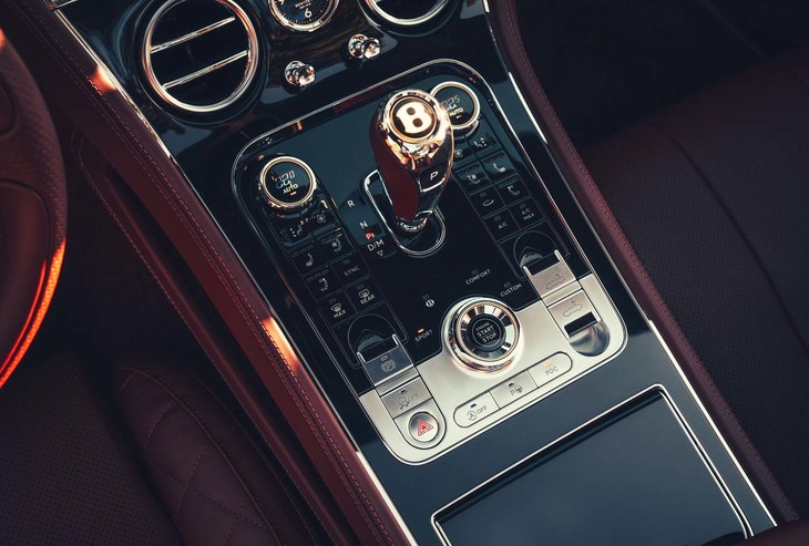 ソフトトップの開閉ボタンはセンターコンソールにレイアウト。スタート／ストップボタンやシフトセレクターなどにも100周年特別仕様の「センテナリーゴールド」が配されている。