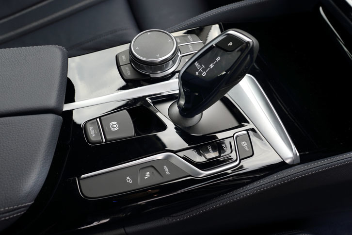 センターコンソールのシフトレバー周辺には、走行モードのセレクターやインフォテインメントシステムの操作スイッチが並ぶ。