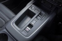 シフトセレクターは背丈のあるレバー式から出っ張りのない高さのトグルスイッチ式に変更。それによって空いたスペースに収納（穴）が用意された。