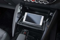 小物入れスペース前方のふたには、開いた際にスマートフォン置き場として使うためのストッパーやグリップが付属する。写真奥の平置きスペースでは非接触充電も可能。