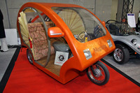 ベンチャー系EVメーカーからの提案のひとつ。「環（めぐる）」と名付けられた、人力車やベロタクシーのような観光需要に向けた3人乗り（運転手＋乗客2名）の三輪EV。最高速度40km/hで航続距離も40kmという。ボディは樹脂の上に和紙を貼り、漆塗りで仕上げてある。