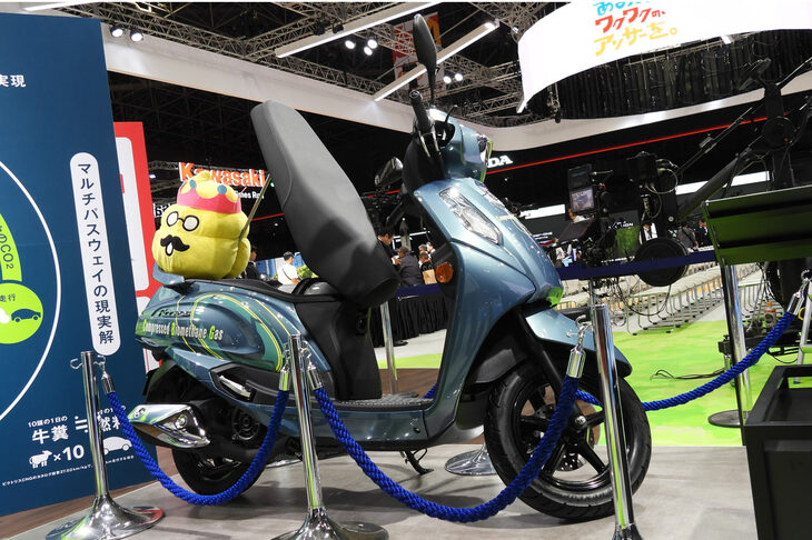 CBG（圧縮バイオメタンガス）仕様のスクーター「アクセス」は、牛フンからCBGを生成することを説明するために、子供たちに人気のキャラクター「うんこ先生」とともに展示。