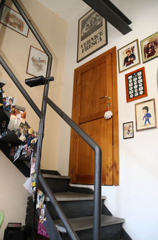 屋根裏部屋に行くには、リビングから伸びるらせん階段をたどる。壁には、写真や友人が描いてくれた似顔絵が。
