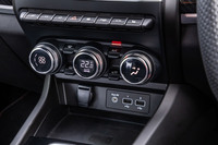 トグルスイッチとダイヤルスイッチ、液晶表示を組み合わせたエアコンの操作パネル。その下にはUSBソケットや12V電源ソケット、スマートフォンワイヤレスチャージャーが機能的に配置されている。