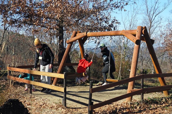 デッキのわきのブランコで遊ぶ子供の図。