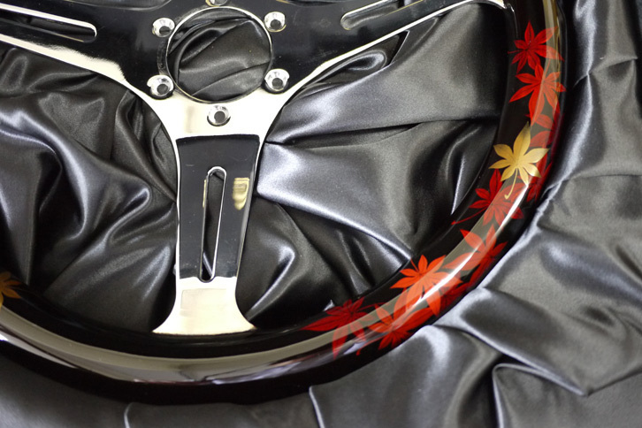 伝統柄をあしらったステアリングは販売も行っている。こちらは、ナルディ製の木製ステアリングをベースに、全体を黒漆で塗り、その上に蒔絵と螺鈿（らでん）による装飾を施している。価格は柄により違うが1本あたり平均70万～100万円程度。制作期間は約半年。