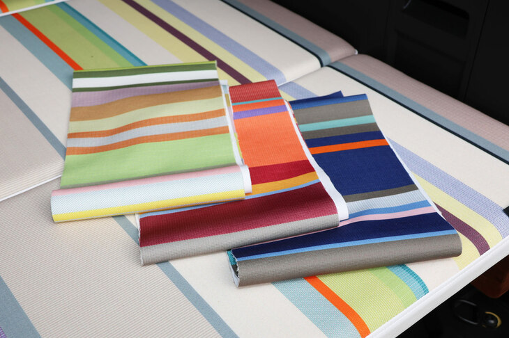 使用される生地には、全部で4種類のおしゃれなストライプ柄を用意する予定。左から、黄色系の「ジェラティ ブラン ジュンヌ」、赤系の「コリウール ルージュ」、青系の「コリウール ロア」、そして展示車のベッドキットに使用されている、紫系の「サン コロン エクリュ」だ。どの色味もすてきなので、購入検討者を大いに悩ませそうだ。