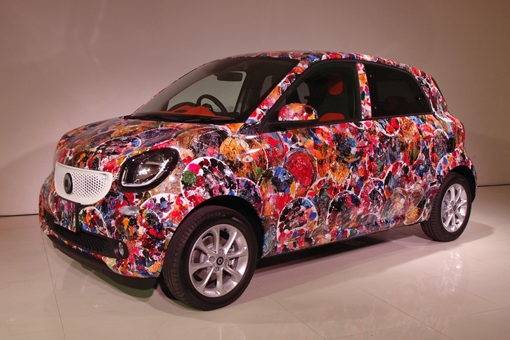 画家 横尾忠則氏の展覧会「横尾忠則 迷画感応術」に出展される、「スマート・フォーフォー」のアートカー。氏が絵画制作の際に使う“紙皿の絵画パレット”をもとにした絵柄で、ボディー全体が覆われている。