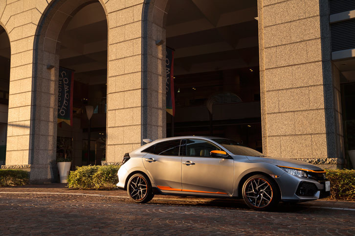 アクセントカラーと同じ、オレンジの陽光を浴びる「シビックハッチバック」。