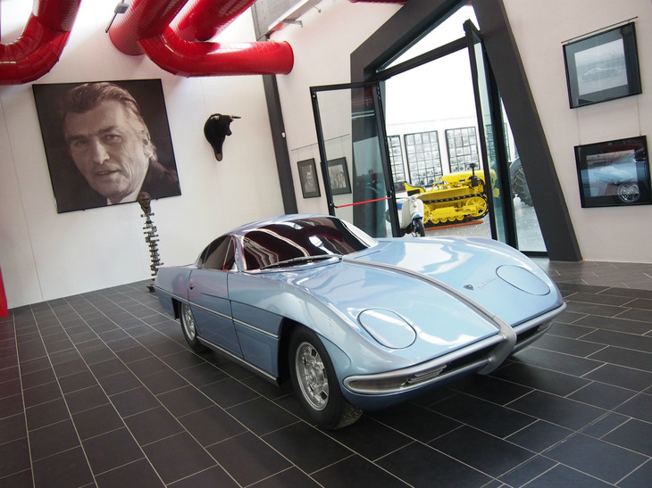 「ランボルギーニ350GTVプロトタイプ」（モックアップ）。フェルッチョのポートレートが見守る。ボローニャ県フーノのフェルッチョ・ランボルギーニ博物館にて。