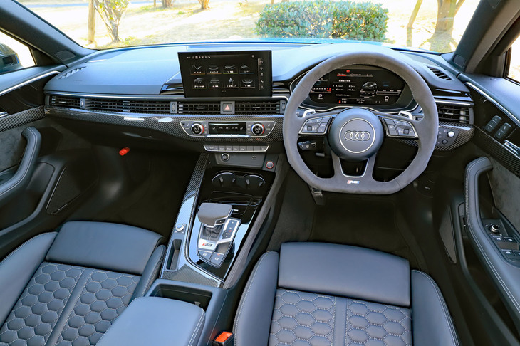 現行「A4」由来のインストゥルメントパネルまわりは、“ボタンレス化”が推し進められる今日にあってはややクラシックな趣。アルカンターラのステアリングホイールやカーボンの装飾パネルは有償オプションである。