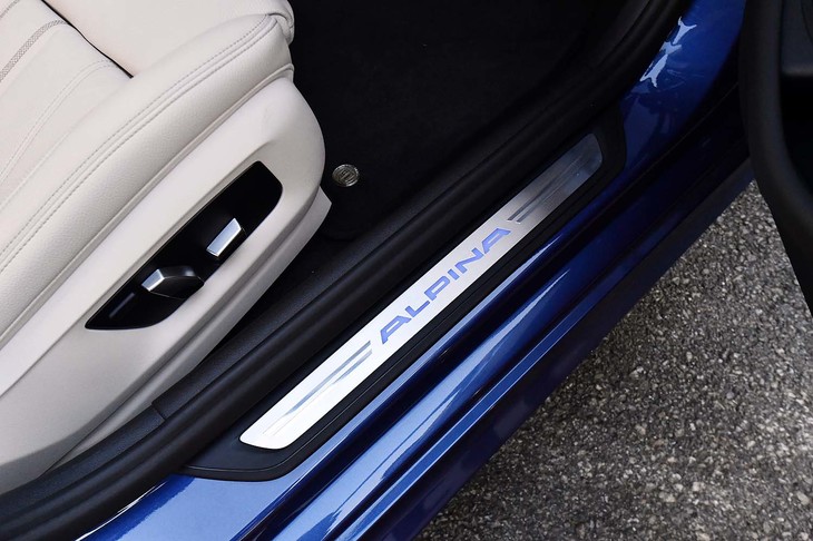 「ALPINA」ロゴ入りのサイドシル。カーペットにはメタルエンブレムが添えられる。