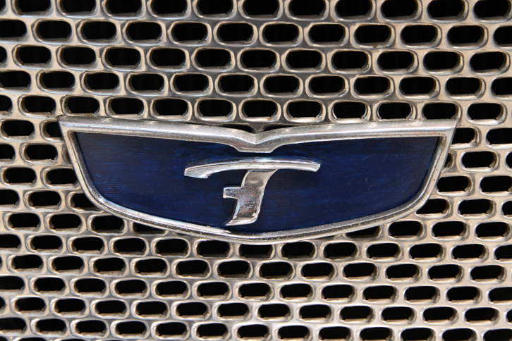 「クーペ」のフロントグリルに貼られたエンブレム。生産車では中央のレタリングがプリンスの「P」になるが、これは「T」とも「F」ともつかない形。ドイツのNSUからの、「Princeはわが社のPrinzとまぎらわしいので使用するな」というクレームに対応したため、ともいわれている。