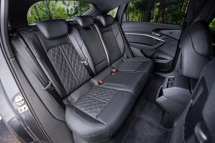 「SQ8スポーツバックe-tron」の後席。標準ボディーでSUVスタイルの「Q8」に比べてルーフ後半がゆるやかに下がるぶんスペースが狭いのではと不安になるが、その心配はなかった。背もたれには40：20：40の分割可倒機構が組み込まれている。