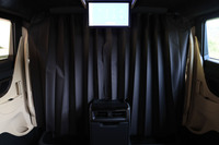 4座の「レクサスLM500h“エグゼクティブ”」が48インチ大型ワイドディスプレイを組み込んだパーティションを採用するのに対して、同じ4座の「スペーシャスラウンジ」では、前席と後席はカーテンによって隔てられる。天井に格納されるリアエンターテインメントシステム用ディスプレイのサイズは14インチ。