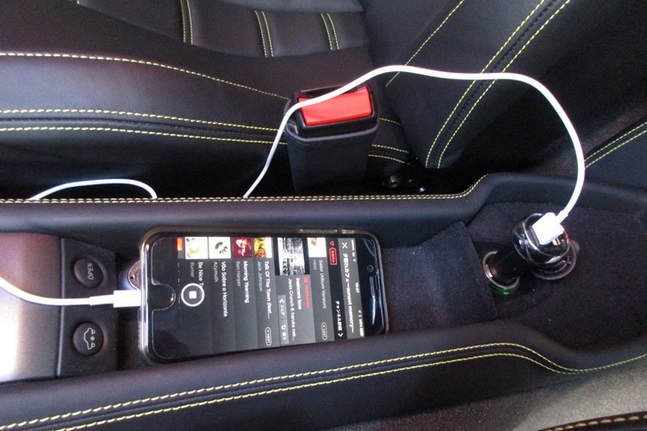 愛車の「458イタリア」でiPhoneを充電しながら、音楽を再生している様子。
