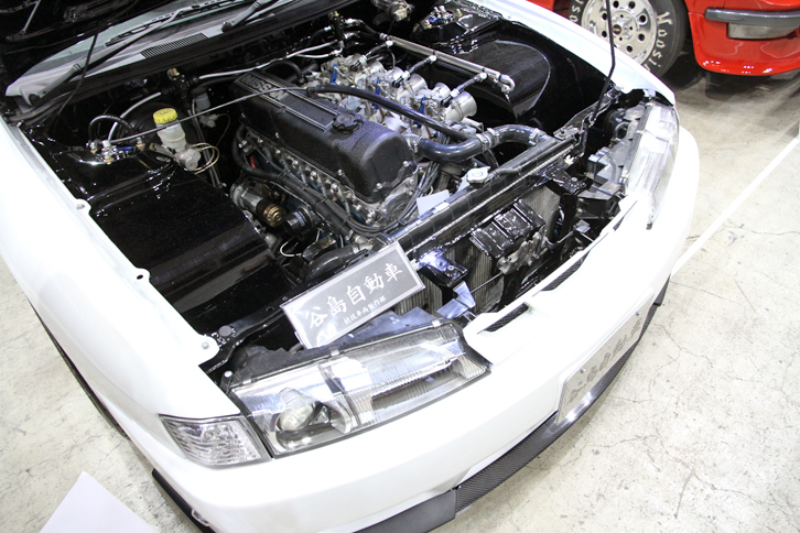 「日産シルビア」（S14）に、L28改3.1リッターのチューンドユニットを積んだ谷島自動車のスペシャル。旧車のエンジンを新しめのものにスワップした例はよくあるが、逆に古いエンジンにコンバートした発想が新鮮。スタッフいわく「L型の音とフィーリングが好きで……今、L型搭載車は高騰しちゃいましたが、この手法ならベース車込みでも300万円くらいで楽しめるんですよ」とのこと。なるほどね。