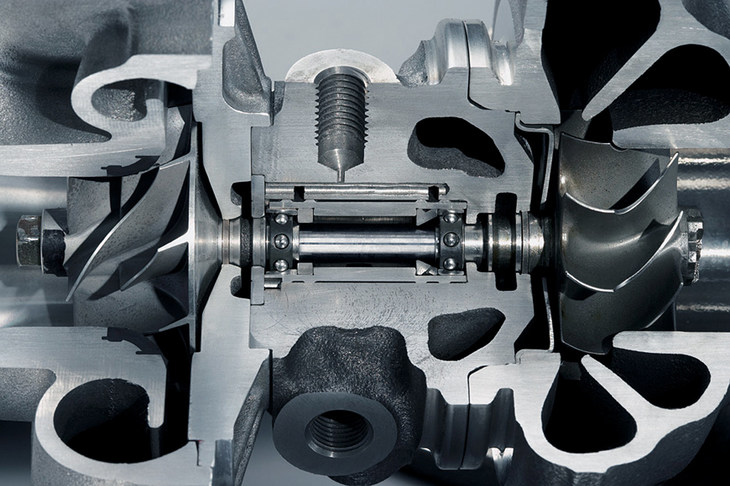 ターボチャージャーのカットモデル。2つのタービンが1本の軸でつながっており、片側のタービンが排気を受けて回転すると、もう片方のタービンも回転し、吸気を圧縮する仕組みとなっている。