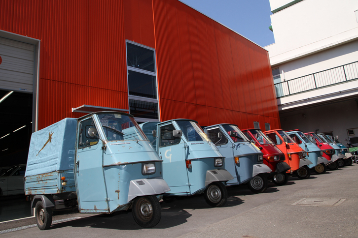 9台そろったイタリアはピアジオ社製のマイクロ三輪トラックである「アペ」（輸出名称は「ベスパカー」）。背景のオレンジ色の壁のおかげで「ここはイタリアか!?」という雰囲気。