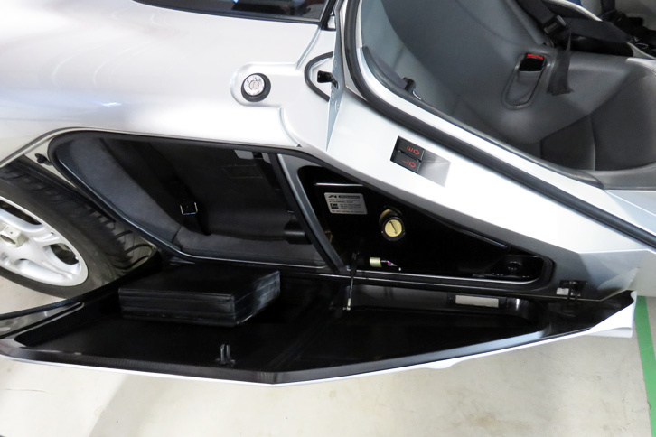 ちなみに「マクラーレンF1」のトランクルームはこちら。跳ね上げ式のドアとリアタイヤの間に備わっていた。