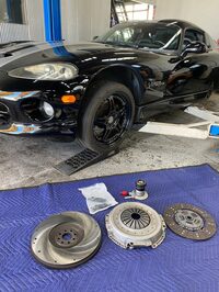 リフトアップされる「バイパー」と、クラッチまわりの交換部品一式。新品だと（リユース品もあるけど）、こんなにピカピカなのね。