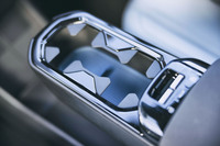 前席のひじ掛けには収納式のカップホルダーを装備。その下方はバッグ類の置き場にも適したスペースとなっている。