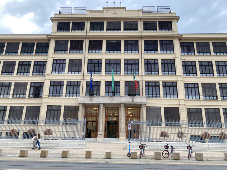 すでにリプライ社のものとなってから、2022年6月に撮影した外観。手前に放置されたシェアリング用の電動アシスト自転車や電動キックスクーターも、自動車の街トリノの変貌を象徴している。